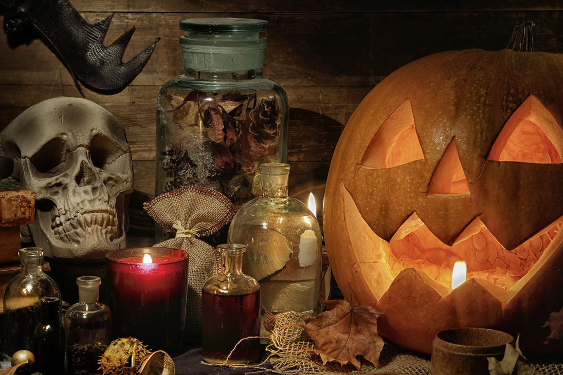 Geschnitzter Kürbis, Kerzen, Totenkopf in einer düsteren Halloween-Stimmung